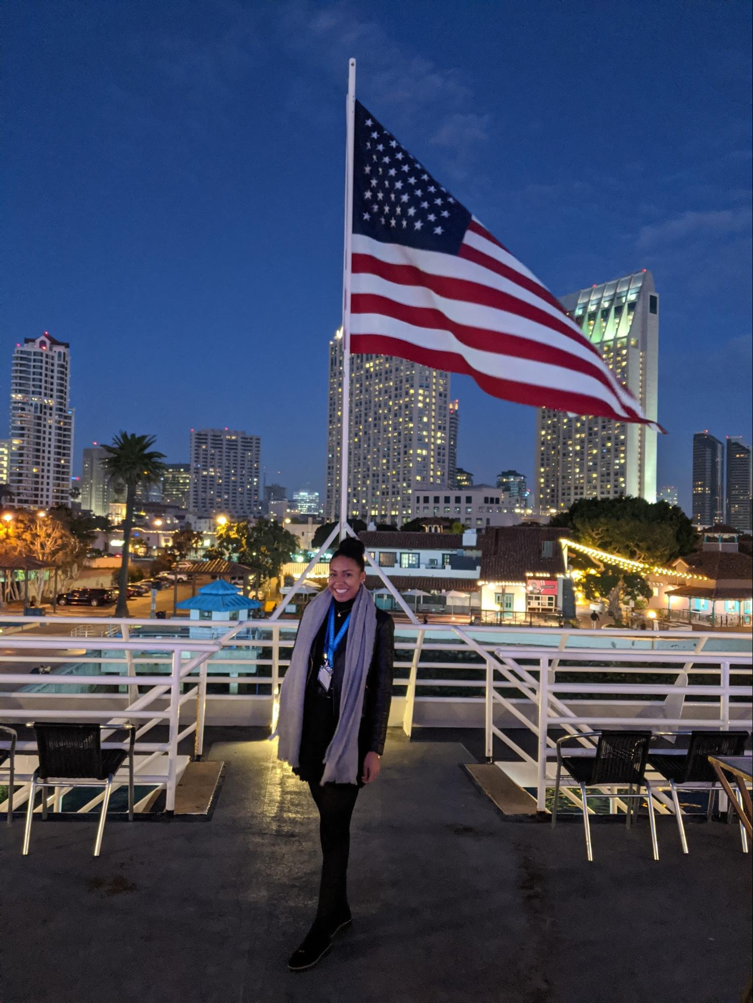 Tamara standing in front of a U.S. flag