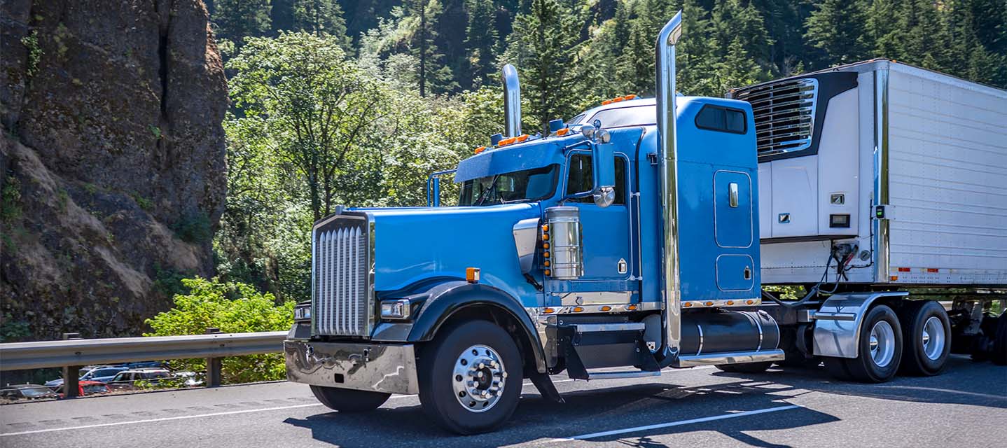 A photo of a semi-truck driving in an urban area.