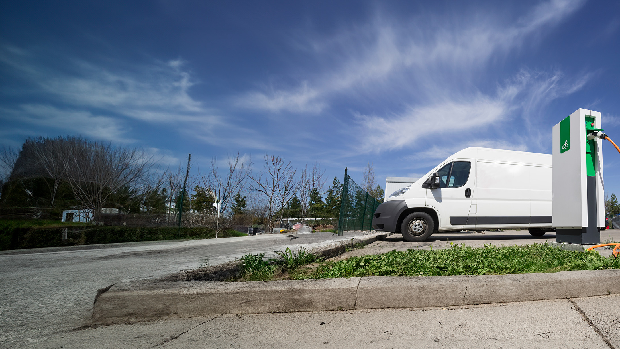 White electric van at a charging station 