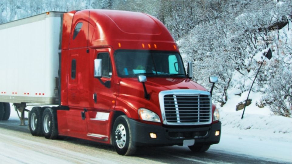 Red truck driving in the snow