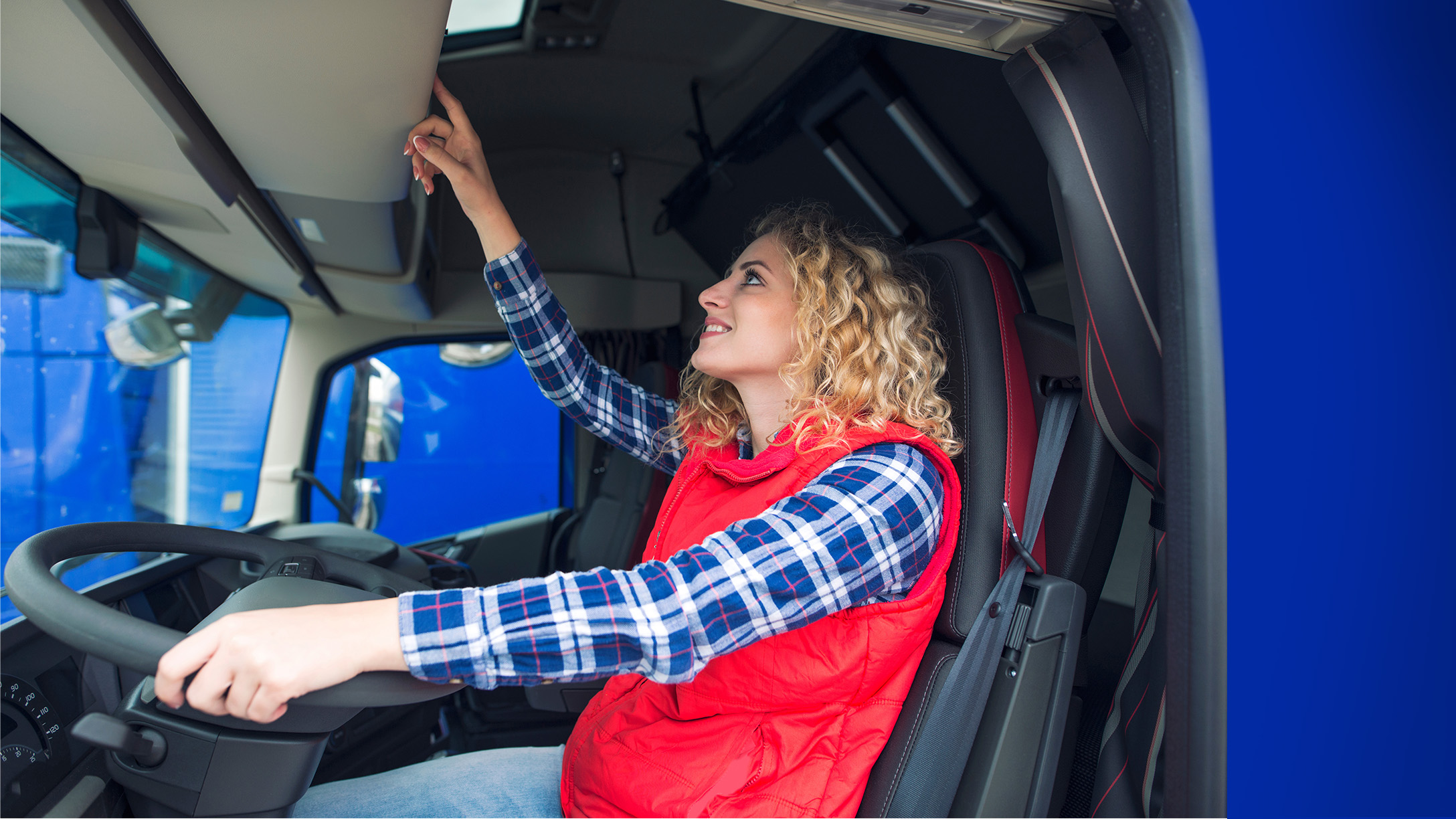 LKW-Fahrerin bedient digitalen Tachographen im Fahrerhaus