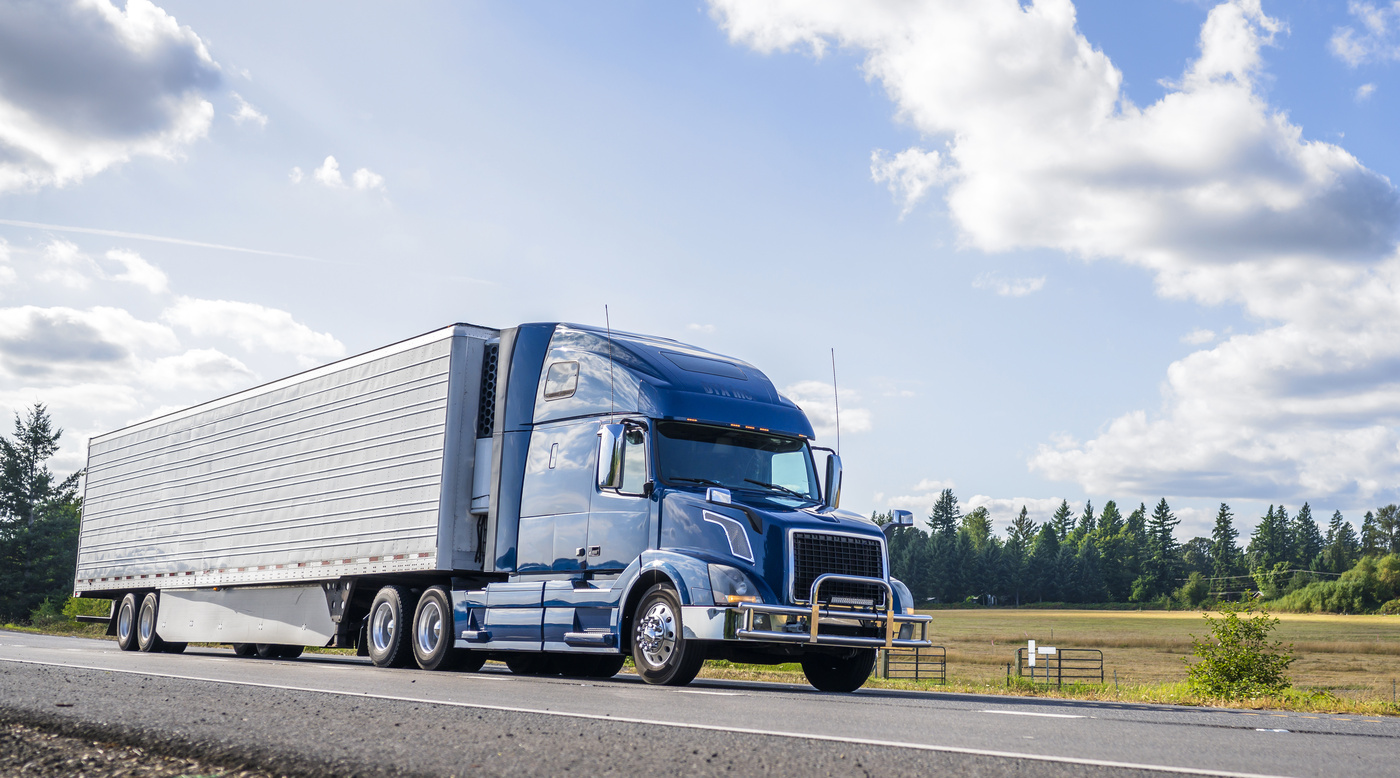 Camión de carga en carretera bajo un cielo despejado, representando el transporte de carga eficiente y seguro.