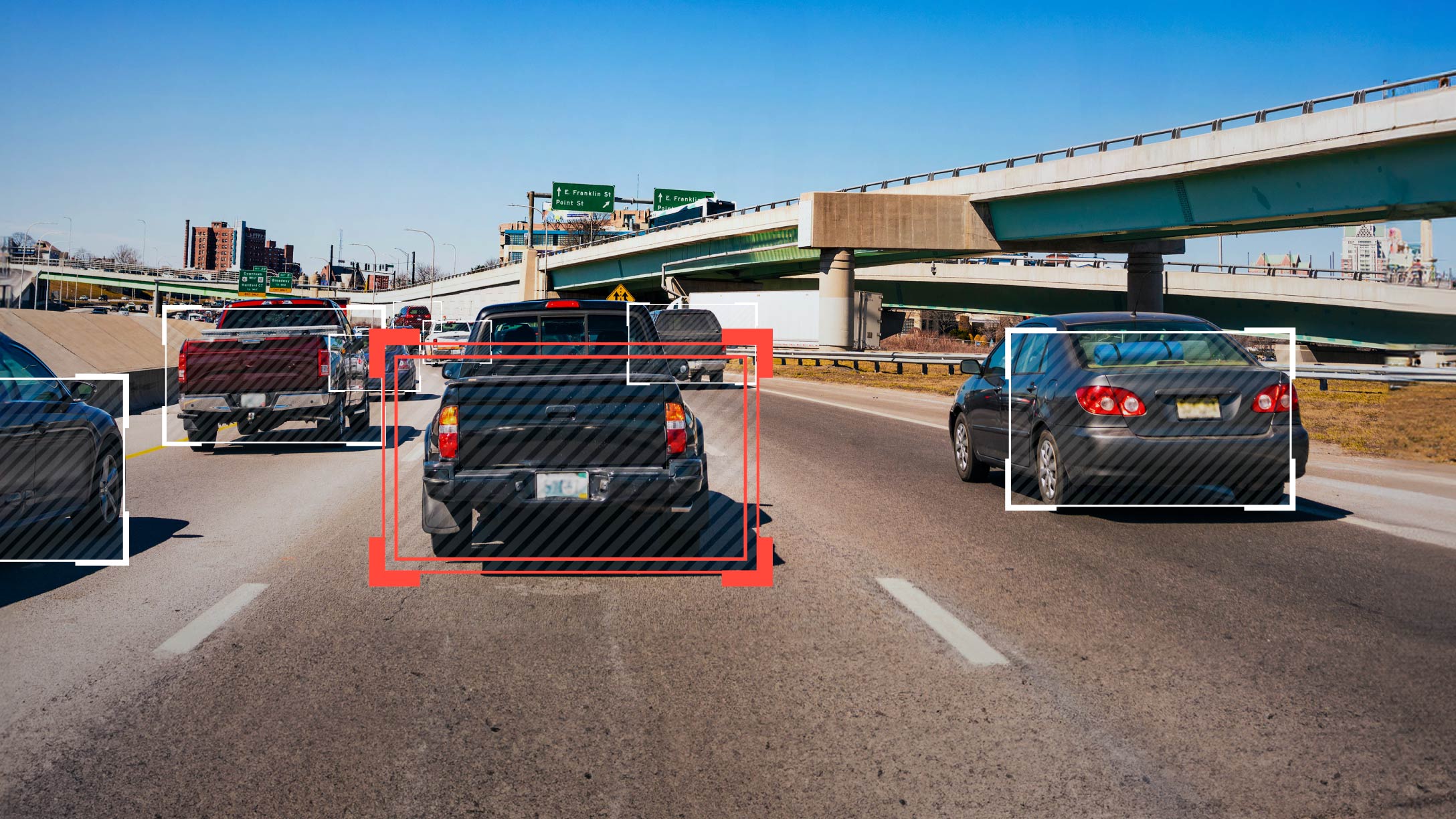 Vehículos en carretera detectados por sistema de video telemática, con recuadros rojos y blancos resaltando los autos.