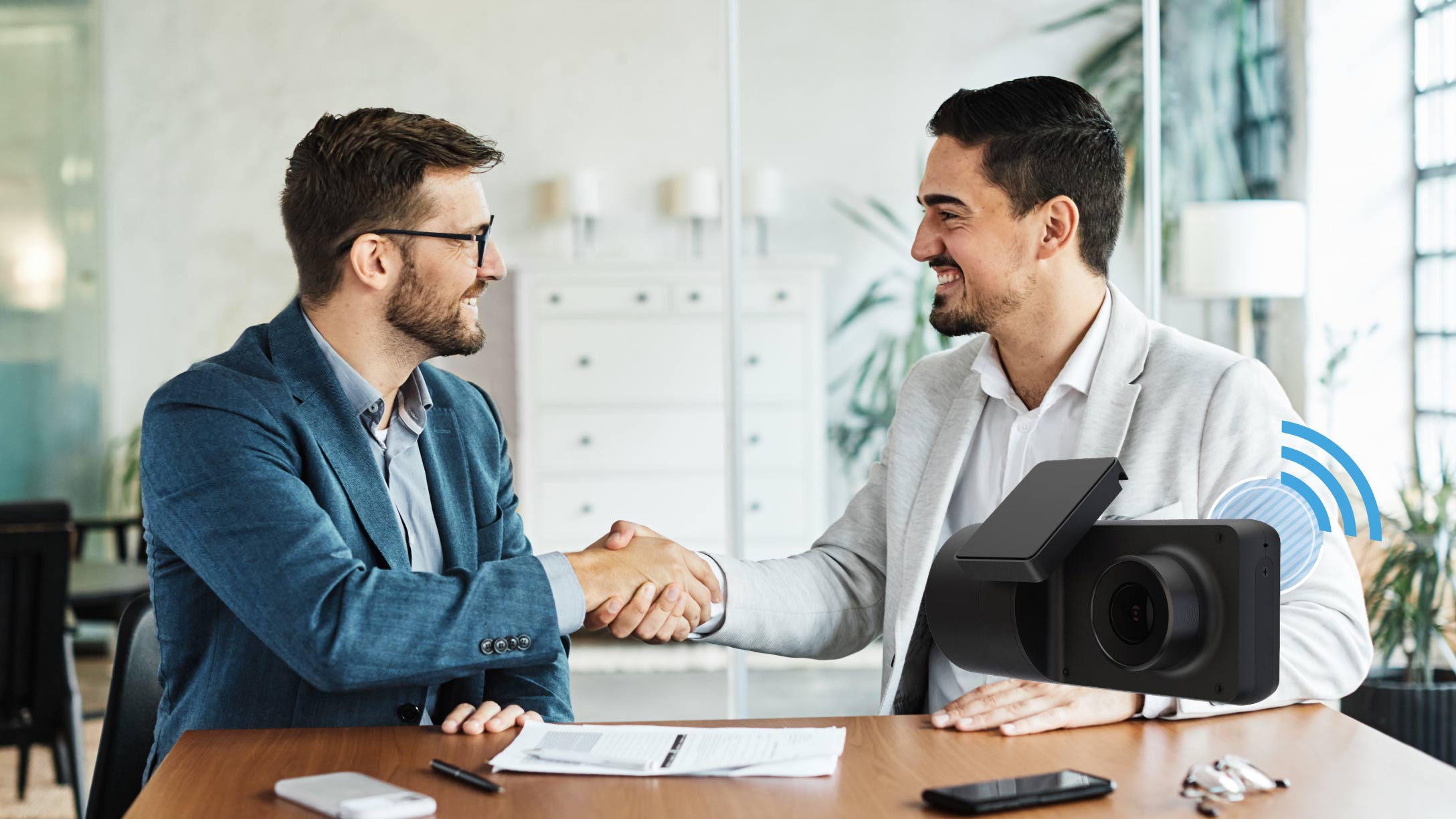 two men shaking hands with the camera on the background
