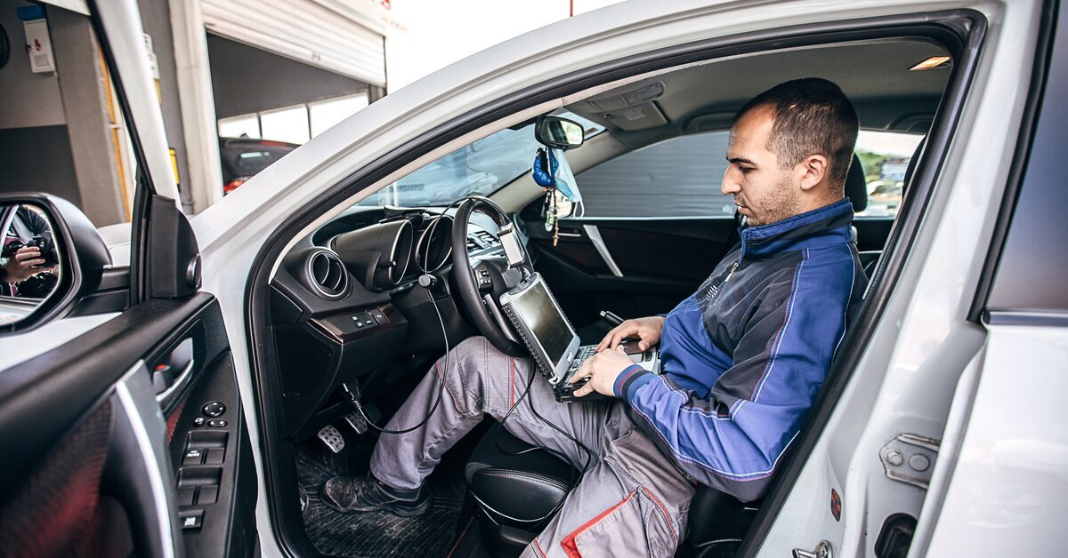 Technicien branchant un outil de diagnostic sur l’ECM d’un véhicule