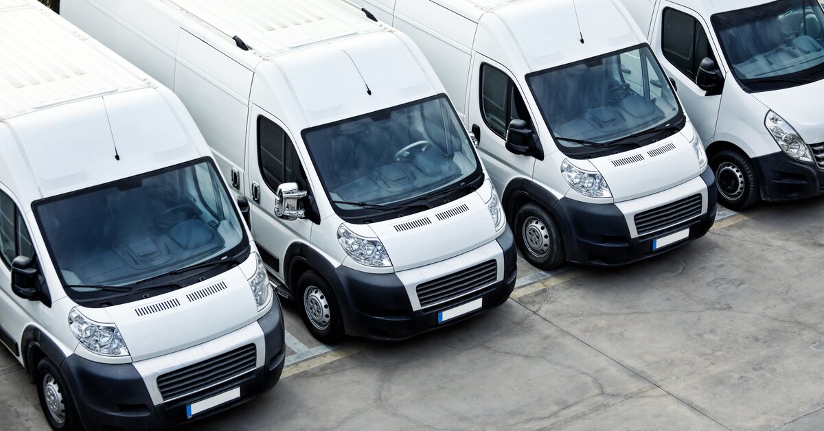  Flotte de véhicules utilitaires légers (VUL) alignés sur un parking d’entreprise.