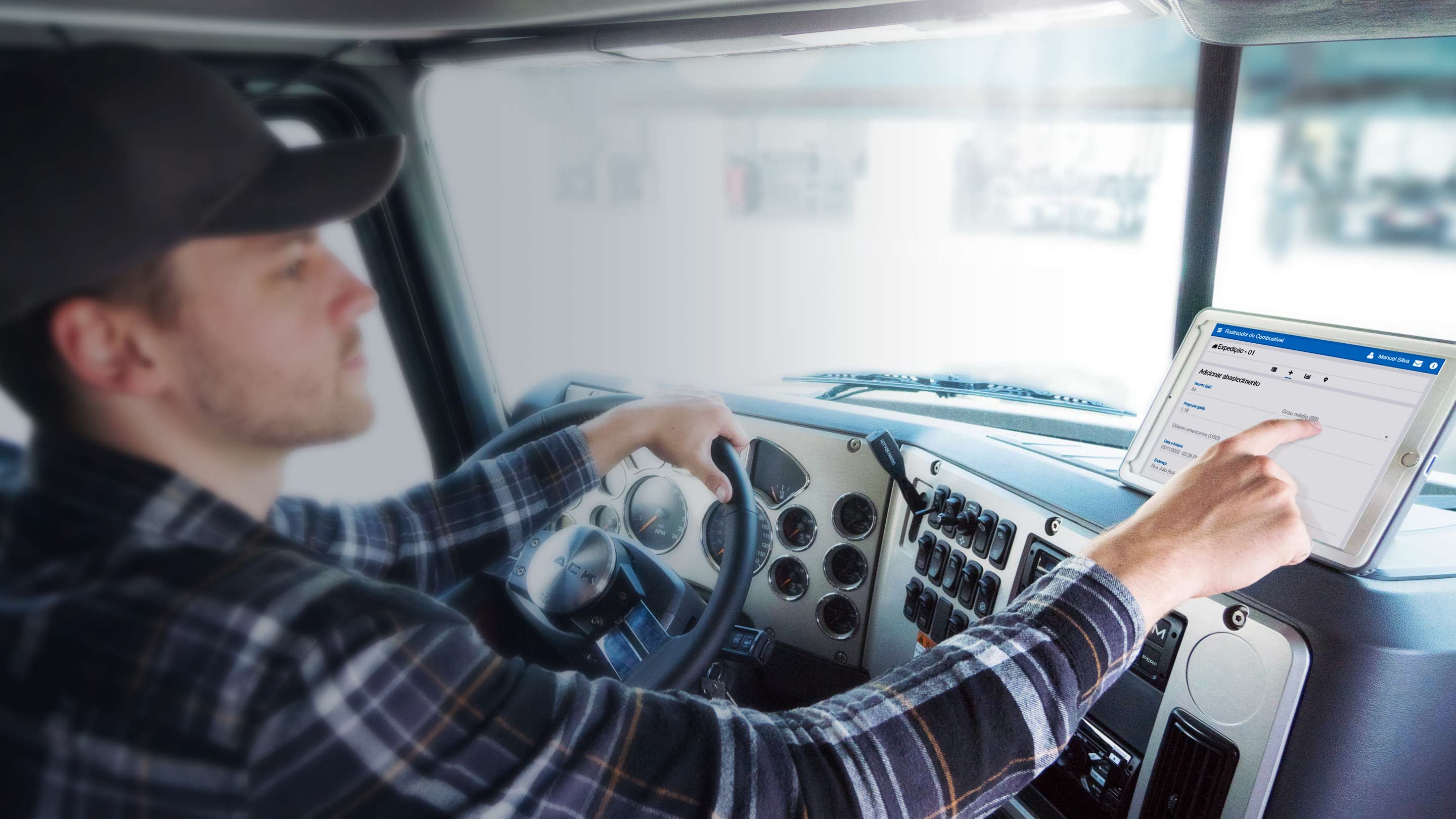 Motorista dentro do caminhao usando um tablet