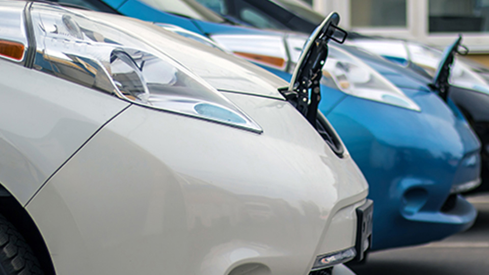 Three vehicles parked beside each other with front of car opened