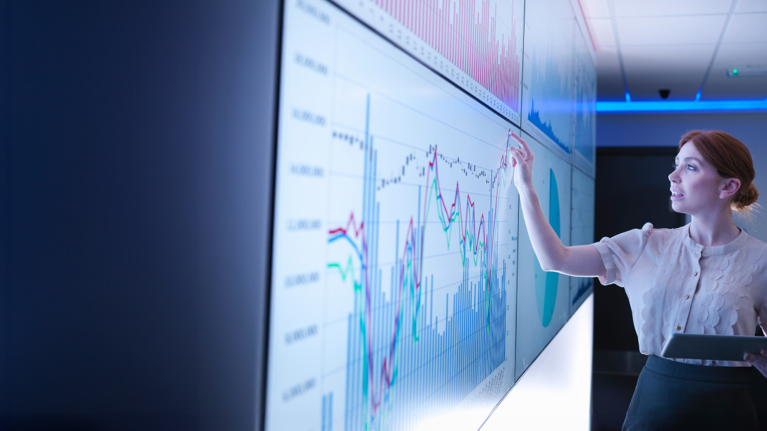 Woman looking at graphs on a screen