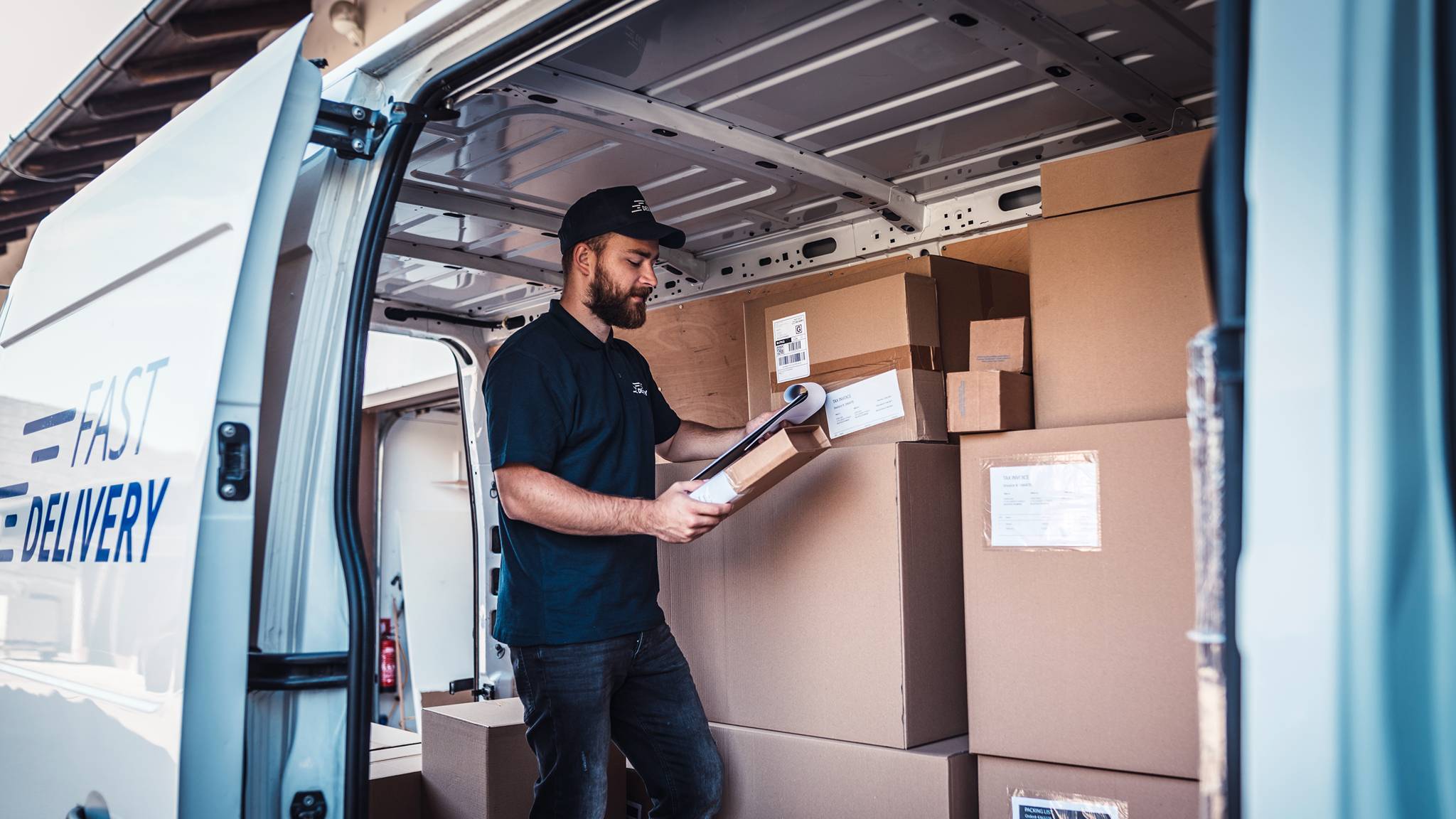 Un livreur inspecte ses colis dans sa camionnette