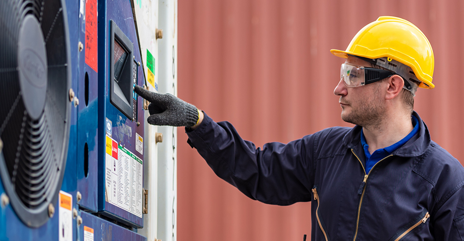 construction worker looking at a cold chain machine